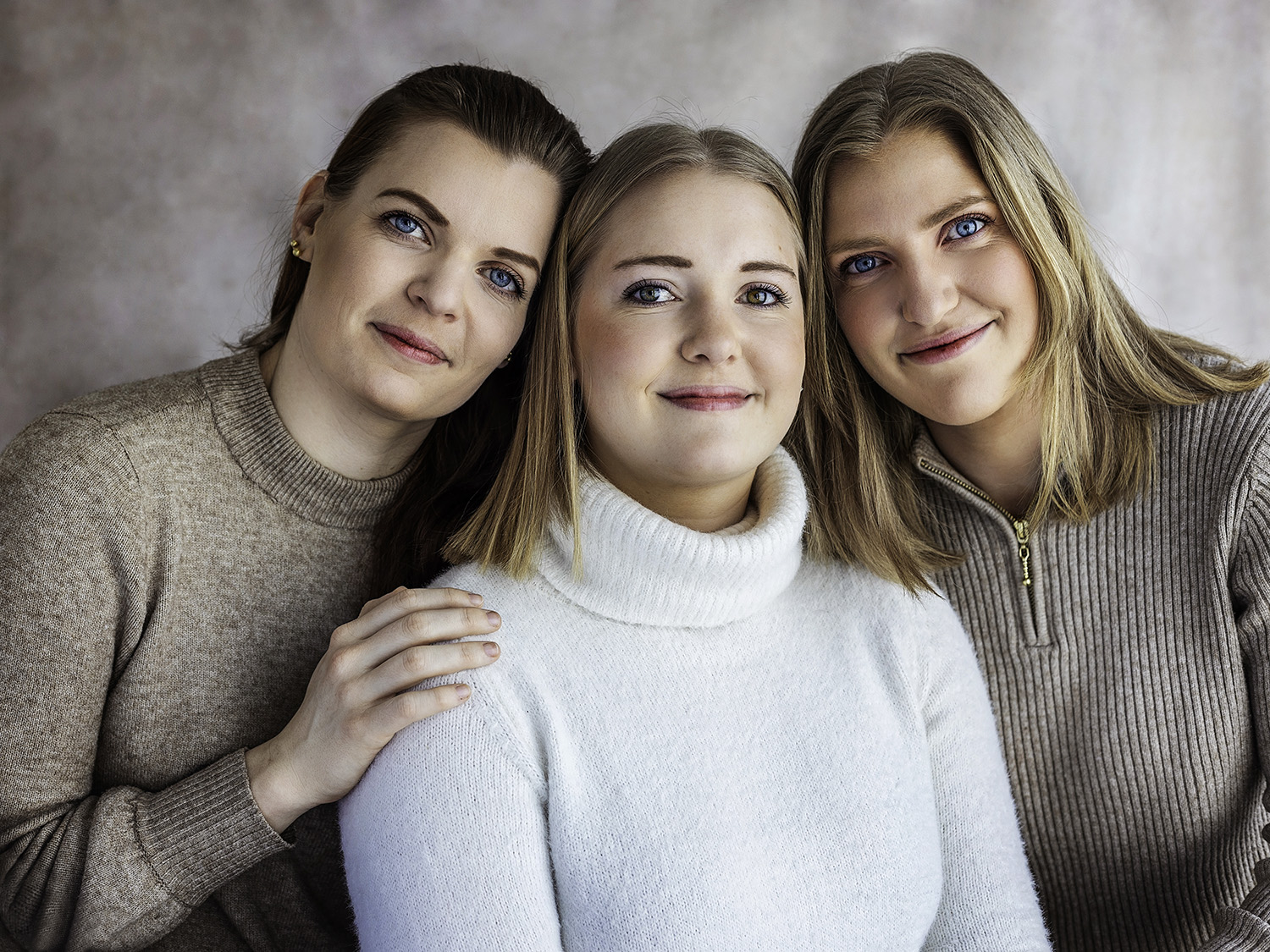 tre unge kvinne smilende og iført strikkede gensere